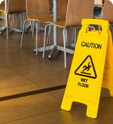 a yellow caution sign on a tile floor